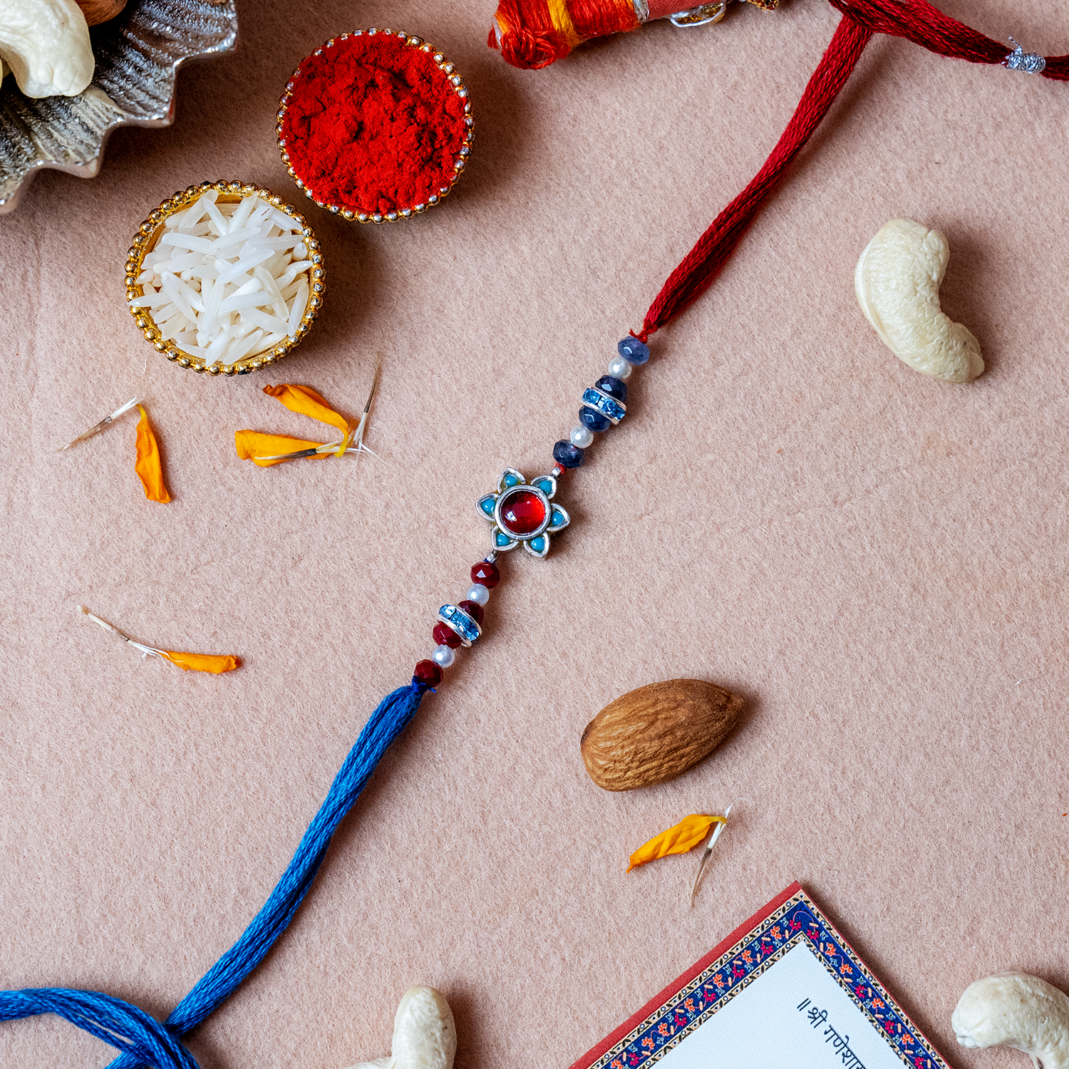 Divine Silver Starburst Floral Rakhi – Handcrafted Ruby & Sapphire Designer Thread for Brother