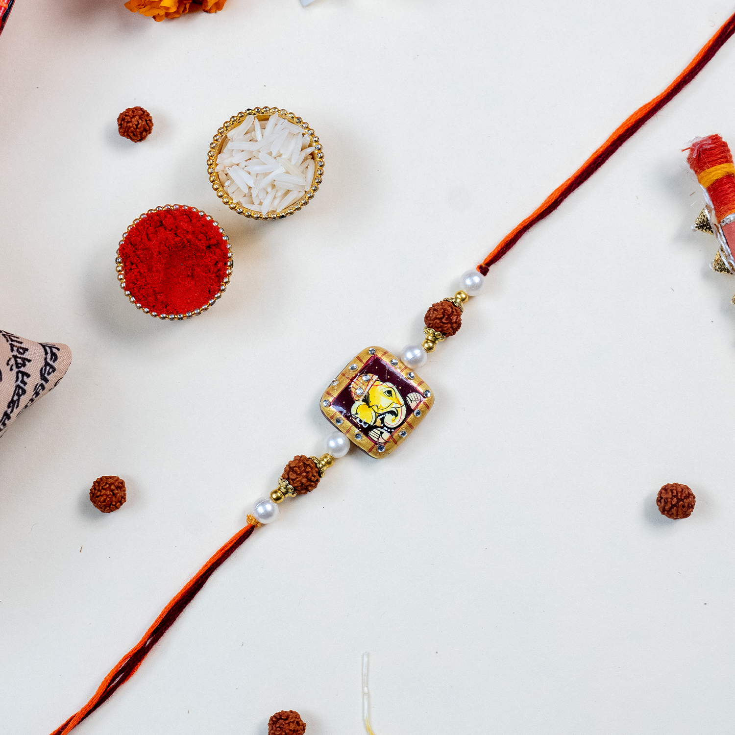 Traditional Divine Ganesha & Pearl Bhaiya Bhabhi Rakhi Combo with Hand-Painted Potli & Scroll Card