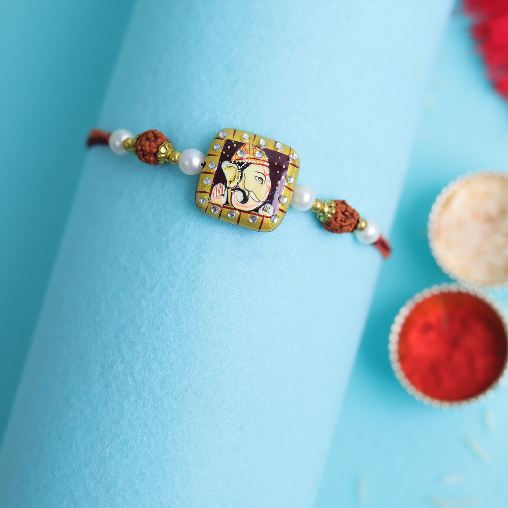 Traditional Divine Ganesha & Pearl Bhaiya Bhabhi Rakhi Combo with Hand-Painted Potli & Scroll Card