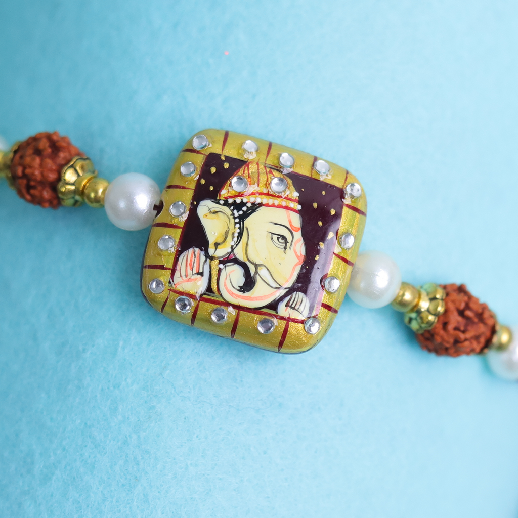 Traditional Divine Ganesha & Pearl Bhaiya Bhabhi Rakhi Combo with Hand-Painted Potli & Scroll Card